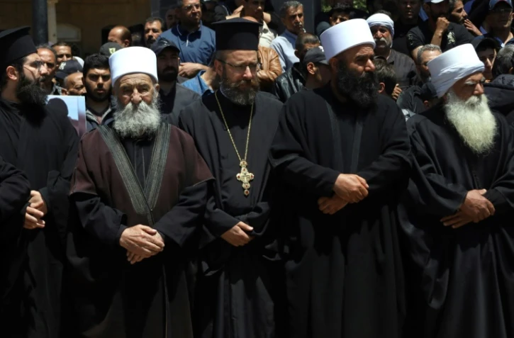 Des religieux chrétiens et musulmans assistent à Salkhad dans le sud de la Syrie, aux funérailles de membres de la communauté druze tués lors de combats confessionnels près de Damas, le 3 mai 2025  
