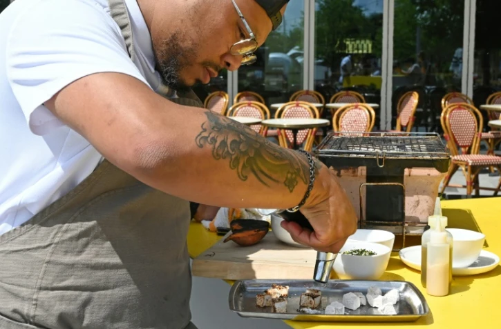 Le chef afro-américain Jerome Grant prépare un plat dans son restaurant "Jackie", à Washington, le 25 juin 2021