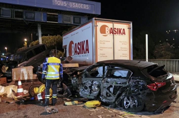 Une épave de voiture sur le lieu d'un accident provoqué par un camion à un péage sur l'autoroute A8 près de Nice, le 29 octobre 2015