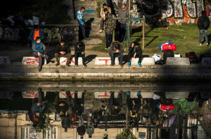 Des migrants assis au bord du quai de Jemmapes, dans le nord de Paris, le 31 octobre 2016