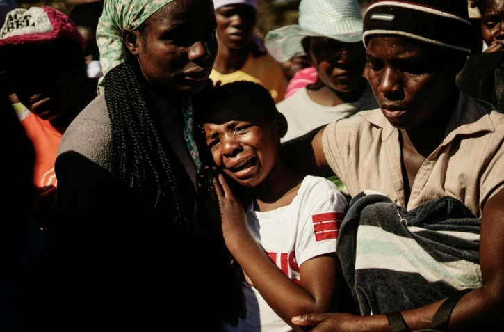 Ahlia Kumire (au centre), fille d'Ishmael Kumire, pleure la mort de son père tué dans la répression d'une manifestation de l'opposition, lors de ses obsèques dans le village de Chinamhora, à 45 km au nord-est d'Harare, au Zimbabwe, le 4 août 2018