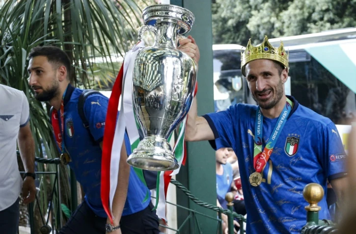 Le capitaine italien Giorgio Chiellini brandit le trophée de l'Euro à côté du gardien Gianluigi Donnarumma au retour de la sélection à Rome le 12 juillet 2021