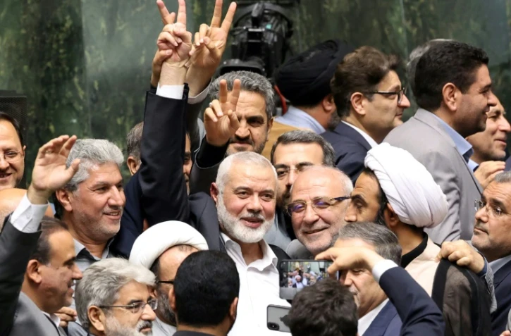 Le chef du Hamas Ismaïl Haniyeh (C) fait le signe de la victoire lors de la cérémonie de prestation de serment du nouveau président iranien, au parlement de Téhéran, le 30 juillet 2024

