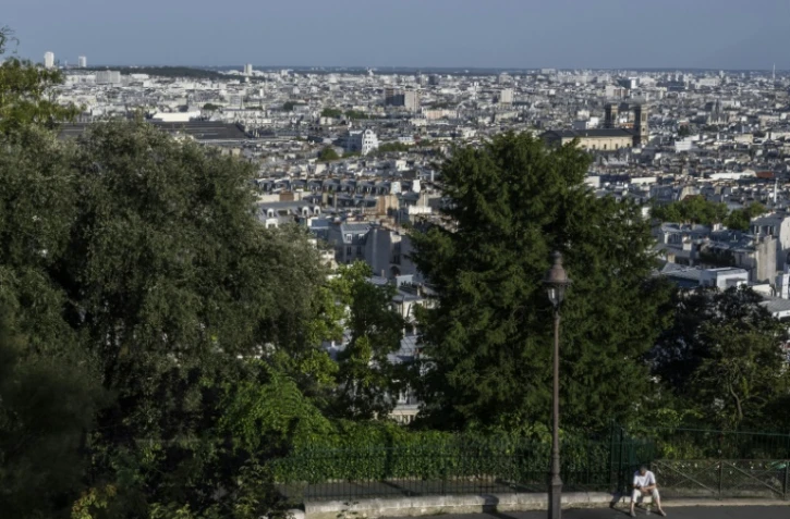 Un homme est assis sur un trottoir de la Butte Montmartre, à Paris, le 12 août 2025, en pleine canicule