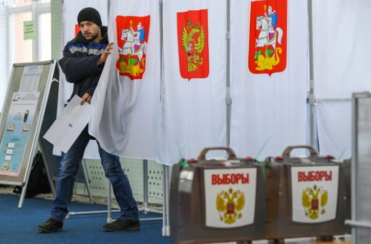 Un citoyen russe sort de l'isoloir, Ă Moscou le 18 mars 2018