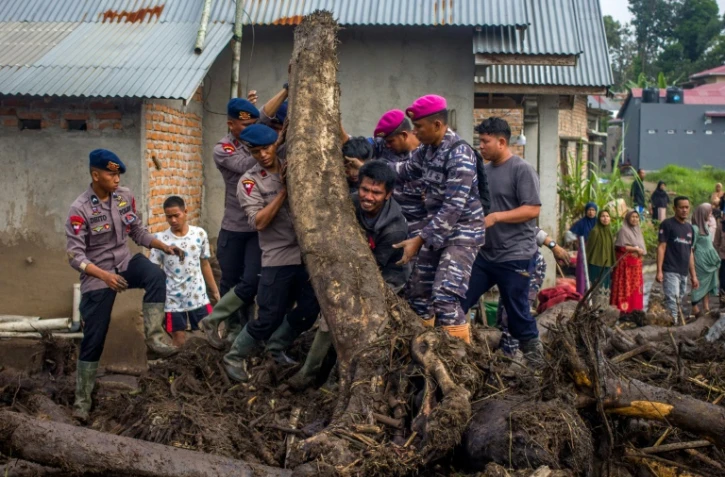 Des membres d'une équipe de secours et des habitants recherche des personnes disparues dans le village de Batu Taba, dans la province indonésienne d'Agam, dans l'ouest de l'île de Sumatra, le 14 mai 2024