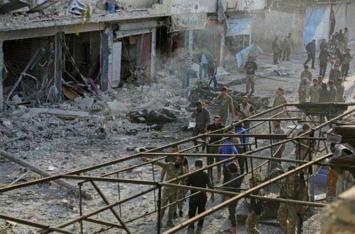 Des combattants syriens soutenus par Ankara inspectent les lieux d'une explosion d'une voiture piégée, à Tal Abyad, dans le nord de la Syrie, le 2 novembre 2019