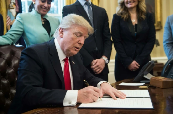 Le président américain Donald Trump signe des décrets dans le bureau ovale de la Maison Blanche, le 30 janvier 2017 à Washington