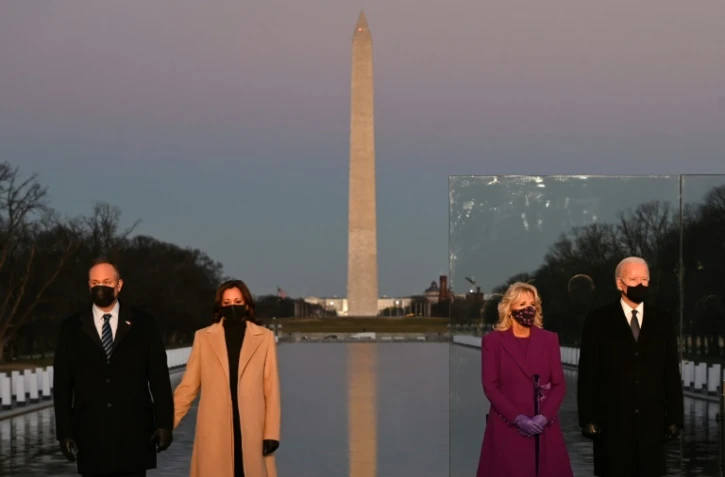 Le président américain élu Joe Biden (d) et son épouse Jill Biden aux côtés de la vice-présidente élue Kamala Harris (2e g) et son mari Douglas Emhoff lors d'une cérémonie en hommage aux victimes du Covid-19 à Washington, le 19 janvier 2021