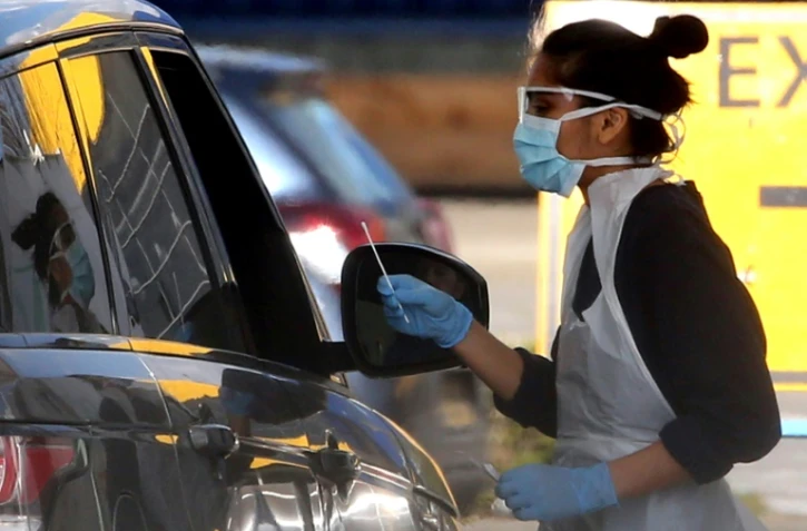 Un membre du personnel soignant teste un membre du NHS ( service de santé publique) au nouveau coronavirus à Londres, le 4 avril 2020 