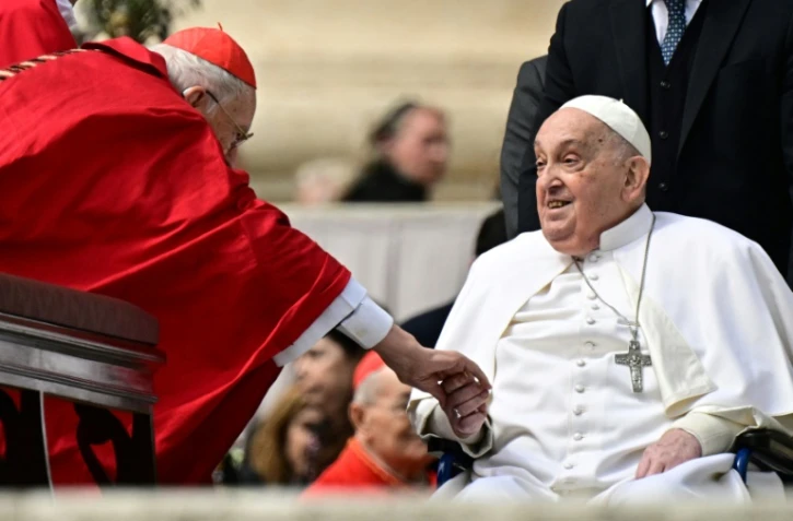 Le pape François salue le cardinal Giovanni Battista Re lors d'une apparition surprise à la fin de la messe du dimanche des Rameaux sur la place Saint-Pierre au Vatican le 13 avril 2025