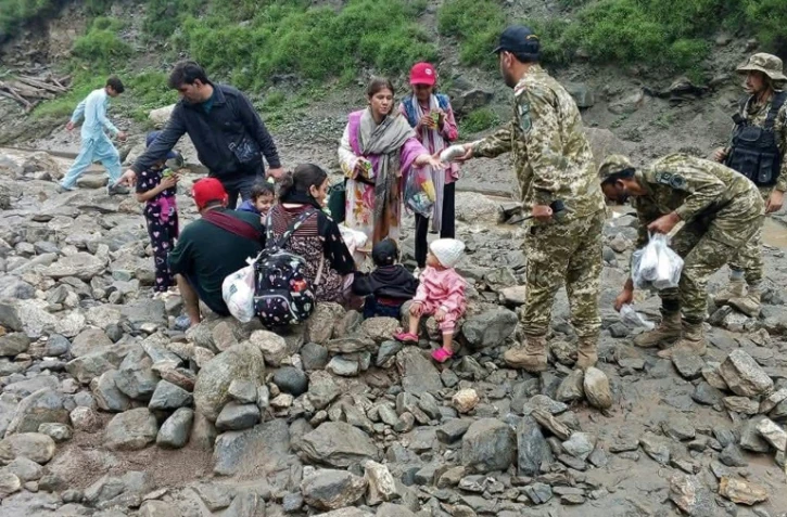 Photo publiée le 22 juillet 2025 par le gouvernement du Gilgit-Baltistan de soldats de l'armée pakistanaise aidant des personnes à évacuer la zone touchée par un glissement de terrain à Babusar, au Pakistan
