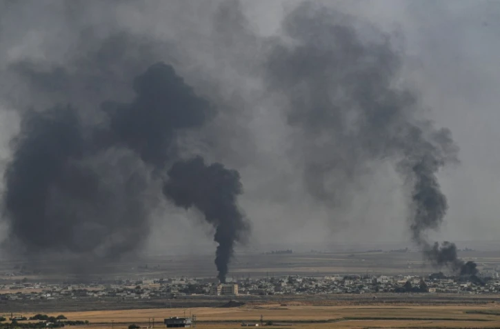 Photo prise dans la ville turque de Ceylanpinar et montrant de la fumée qui s'élève au dessus de la ville syrienne de Ras al-Aïn, le 11 octobre 2019