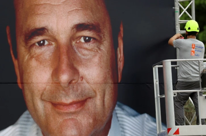Un travailleur installe un portrait géant de Jacques Chirac sur la riviera à Nice, le 27 septembre 2019.