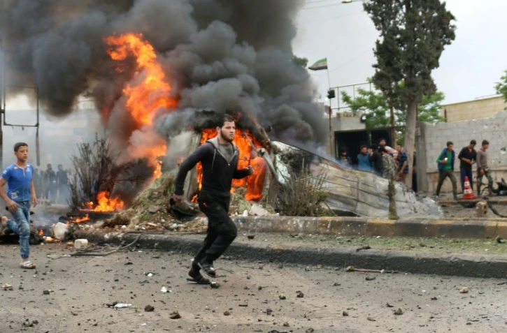 Des habitants courent dans une rue de la ville rebelle d'Azaz après l'explosion d'une voiture piégée, le 3 mai 2017 dans le nord de la Syrie