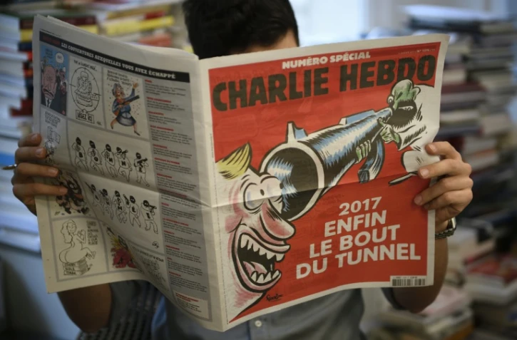 Un journaliste lit un numéro spécial de Charlie Hebdo à paraître mercredi, le 3 janvier 2017 à Paris