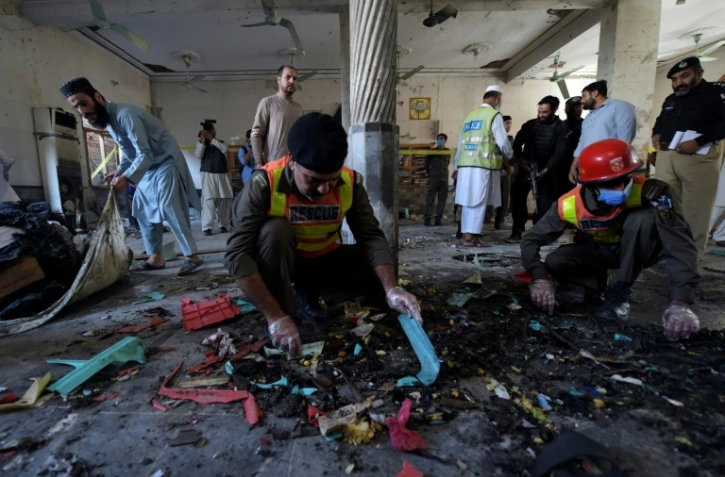 Des secouristes pakistanais sur le site d'une explosion dans une madrassa à Peshawar, le 27 octobre 2020