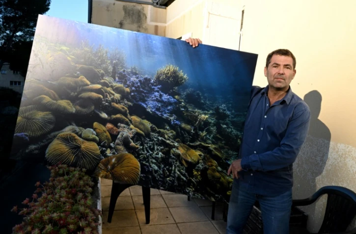 Le plongeur et photographe française Alexis Rosenfeld avec une de ses photos de coraux à Marseille, le 24 janvier 2022