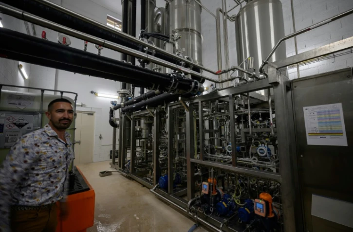 Un employé pose à côté d'une unité de désalcoolisation du vin dans le laboratoire du Chai sobre, le 25 juin 2025 à à Vic-Fezensac, dans le Gers 