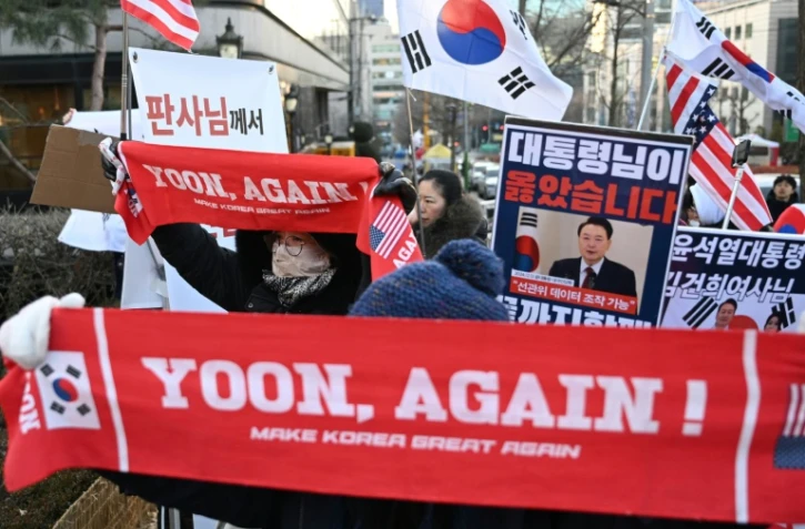 Des partisans de l'ancien président sud-coréen destitué, Yoon Suk Yeol, rassemblés devant le tribunal du district central de Séoul où doit se tenir son dernier procès pénal pour insurrection, le 13 janvier 2026