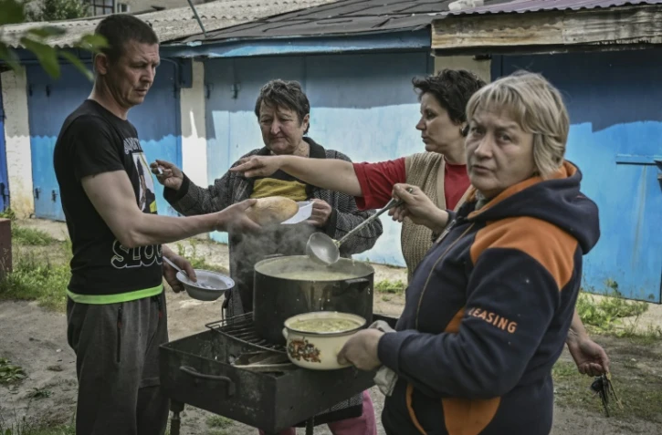 Des habitants de Lyssytchansk, en Ukraine, cuisinent à l'extérieur de leurs habitations, le 26 mai 2022