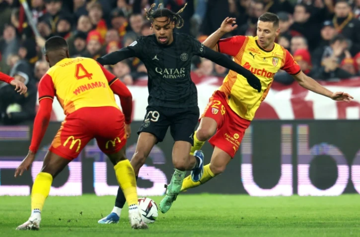 L'attaquant parisien Bradley Barcola (c) entre les Lensois Kevin Danso et Przemyslaw Frankowski, le 14 janvier 2024 à Lens