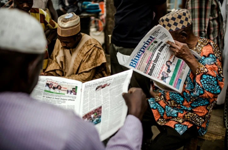 Un homme lit un journal annonçant la victoire du sortant Muhammadu Buhari à la présidentielle, le 27 février 2019 à Kano, dans le nord du Nigeria.
