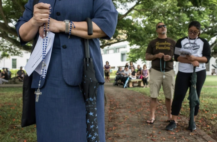 Des fidèles catholiques prient à Hagatna sur l'île de Guam le 13 août 2017