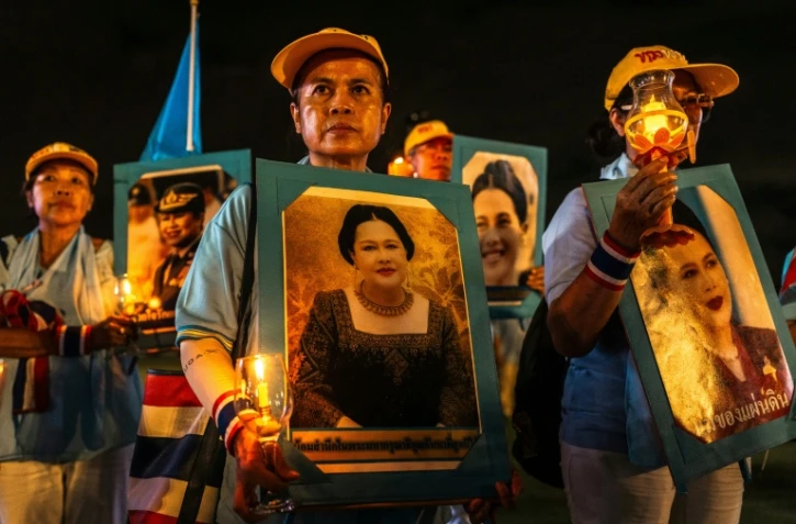 Des partisans de la famille royale tiennent des portraits de la reine mère Sirikit, décédée vendredi, ici le 12 août 2025 à Bangkok