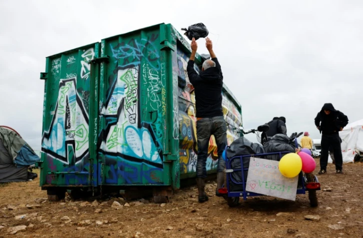 Un participant nettoie le site militaire où s'est déroulée une rave party "teknival" à Cornusse, près de Bourges, le 4 mai 2026 dans le Cher