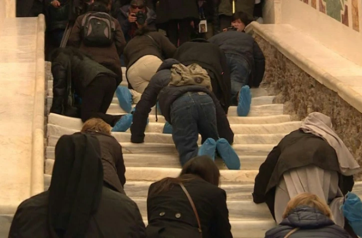 Capture d'écran d'une vidéo de l'AFPTV filmant, le 12 avril 2019 à Rome, des pèlerins gravissant à genoux l'escalier qu'aurait emprunté le Christ avant de comparaître devant Ponce Pilate