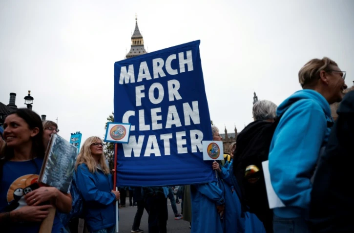 Des manifestants participent à une "Marche pour l'eau propre" appelant le gouvernement à "mettre fin à l'empoisonnement des eaux britanniques", le 3 novembre 2024 à Londres