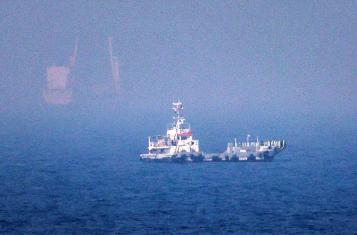 Des navires naviguent près du détroit d'Ormuz, au large de la côte orientale des Émirats arabes unis, à Khor Fakkan, le 13 juillet 2026