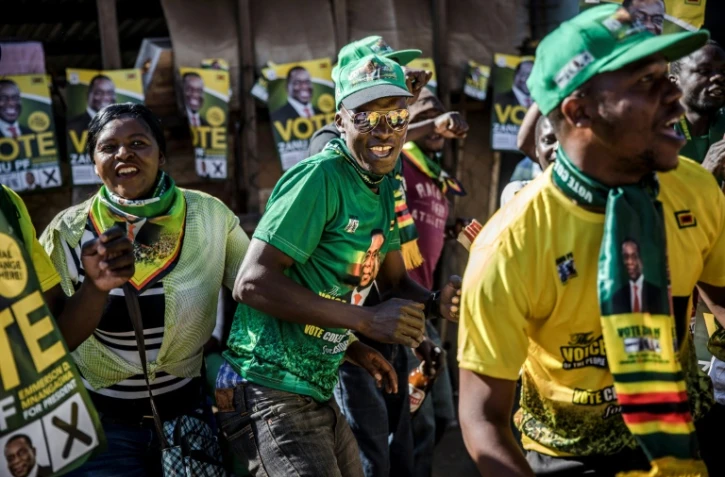Des sympathisants du parti au pouvoir au Zimbabwe, la ZANU-PF, fêtent la victoire annoncée du président Emmerson Mnangagwa à la présidentielle, le 3 août 2018 dans la banlieue d'Harare 