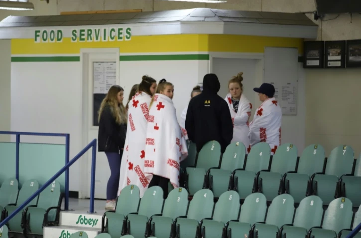 Des personnes en deuil dans la patinoire Humboldt, Saskatchewan, le 7 avril 2018 au lendemain de la collusion entre un car et un camion, qui a fait 15 morts