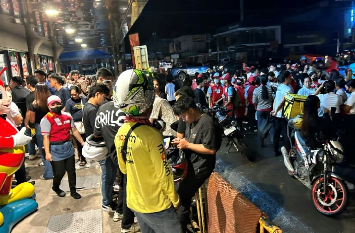 Des habitants regroupés dans une rue après un séisme de magnitude 7,6 à Butuan, dans le sud de l'île de Mindanao, le 2 décembre 2023 aux Philippines