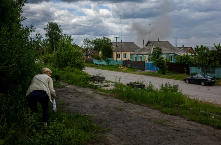 Une femme s'abrite des bombardements dans un village récemment repris aux forces russes, près de kharkiv, le 25 mai 2022