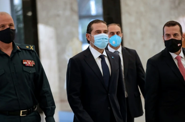Portant un masque, Saad Hariri (C), nommé Premier ministre du Liban pour la quatrième fois, arrive au palais présidentiel de Baabda à l'est de Beyrouth, le 22 octobre 2020