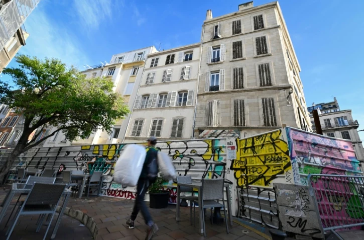 Un homme marche devant le site où huit personnes sont mortes lors de l'effrondrement de deux immeubles, photo du 25 octobre 2019