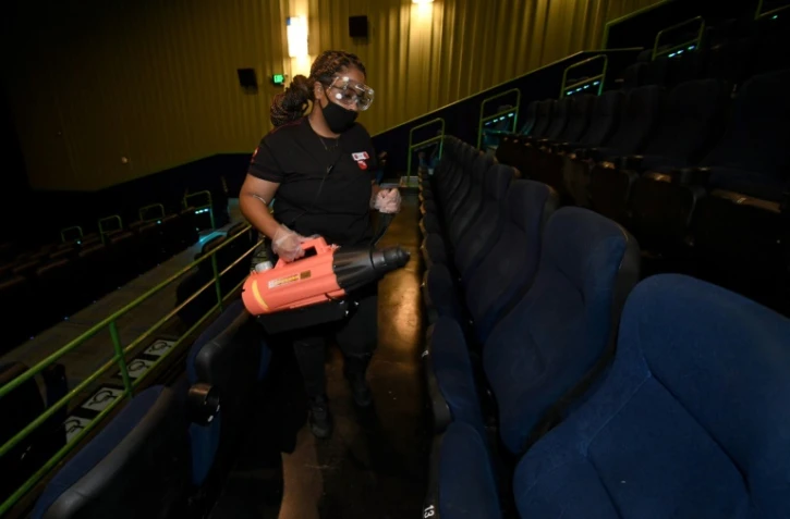 Une employée d'un cinéma de Las Vegas désinfecte des fauteuils