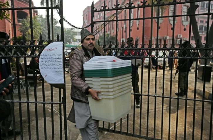 Un homme récupère du matériel électoral dans un centre de distribution à Lahore le 7 février 2024, un jour avant les élections nationales au Pakistan