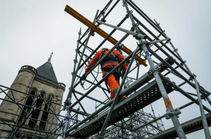 Un employé travaille sur la façade de la cathédrale de Saint-Denis pendant les travaux de reconstruction de la flèche, le 4 février 2025 près de Paris
