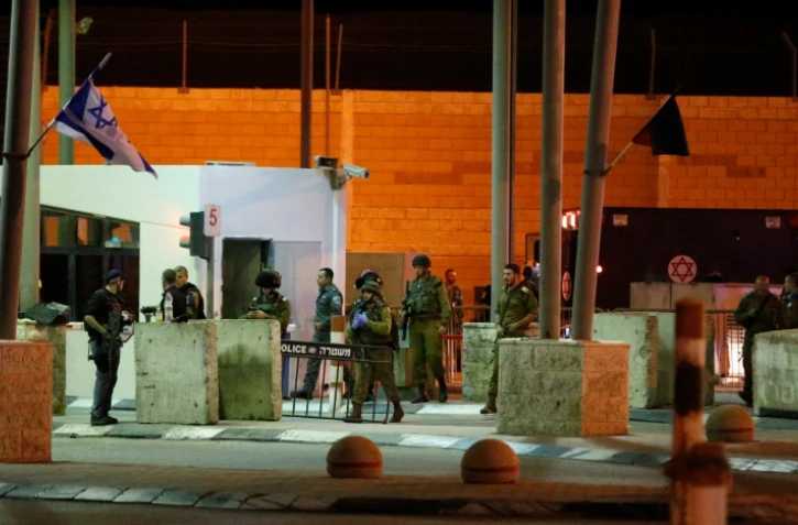 Des membres des forces de sécurité israéliennes sur les lieux d'une attaque au couteau au point de passage de Qalandia entre Ramallah et Jérusalem, le 30 septembre 2016