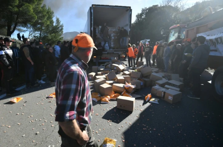 Les agriculteurs vident un camion transportant des légumes de Belgique, au péage Montélimar-Sud de l'autoroute A7, le 24 janvier 2024