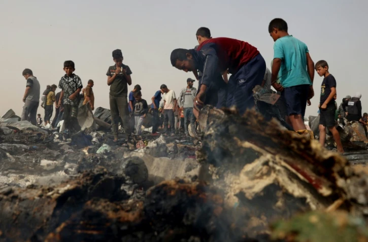 Des Palestiniens constatent les dégâts dans le camp pour personnes déplacées bombardé par l'armée israélienne à Rafah, dans le sud de la bande de Gaza, le 27 mai 2024