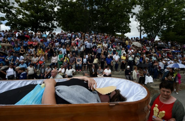 Une femme portée dans un cercueil lors d'une procession le 29 juillet 2019 à Santa Marta de Ribarteme, près de Nieves dans le nord-ouest de l'Espagne