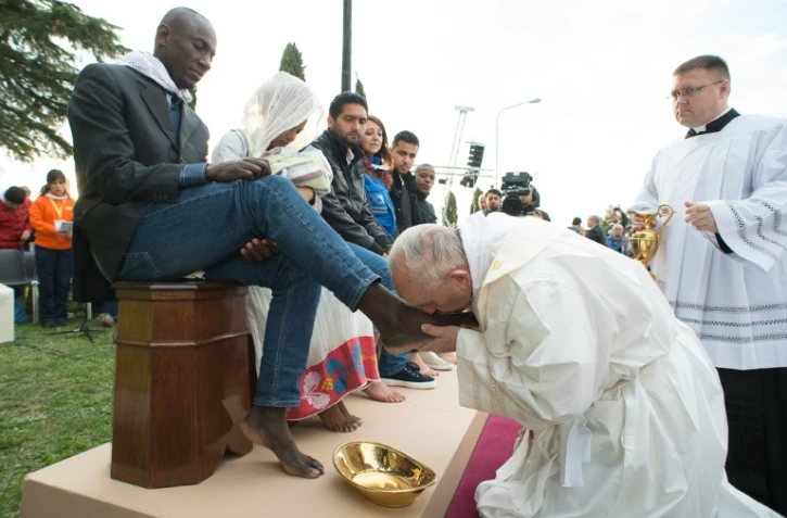 Photo fournie par les services de presse du  Vatican montrant le pape François accomplissant le rituel du lavement des pieds au centre d'accueil pour migrants à Castelnuovo di Porto, près de Rome, le 24 mars 2016
