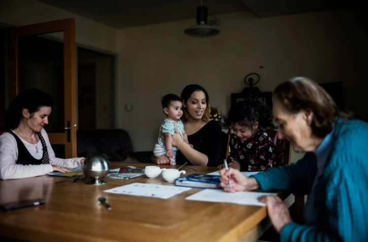 Chahad Khadiri (C), joue avec ses enfants, aux côtés de Marie-Thérèse, 87 ans et et Chrystelle, 40 ans, à Saint-Igny-de-Roche, en Saône-et-Loire, le 10 janvier 2018