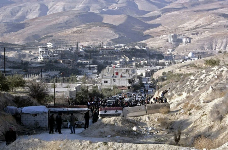 Photo fournie par l'agence officielle syrienne Sana le 11 janvier 2017 montrant des habitants des villages de la région rebelle de Wadi Barada qui attendent de pouvoir quitter la zone