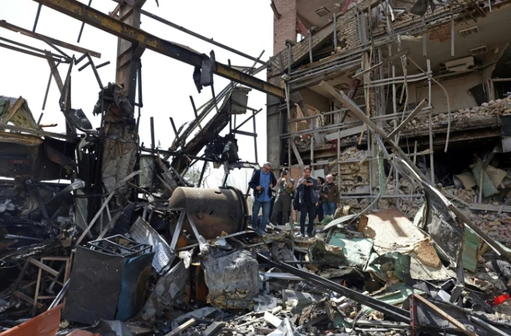 Des représentants des médias se rassemblent autour du bâtiment endommagé de l’université Shahid Beheshti après une frappe, à Téhéran, le 4 avril 2026